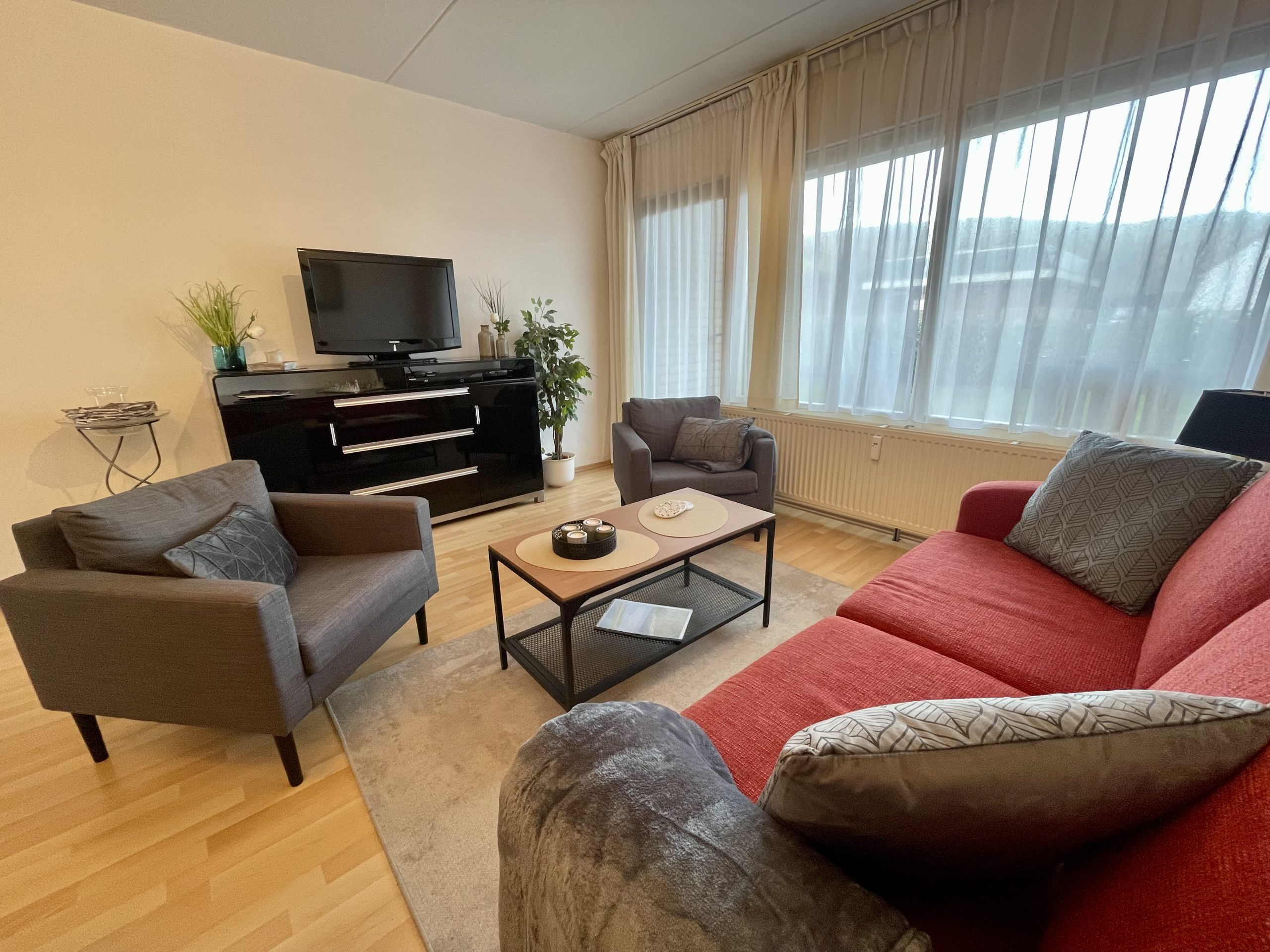 Foto Wohnzimmer Beach Appartement 3 mit Fernseher auf einem Sideboard, Sofa und Sesseln