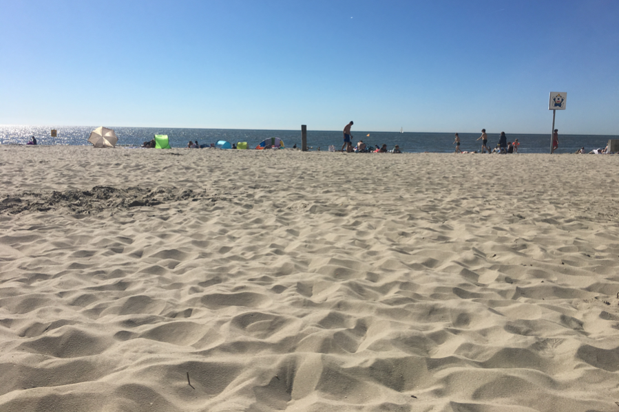 Foto Sand am Strand und am Horizont die Nordsee und blauer Himmel