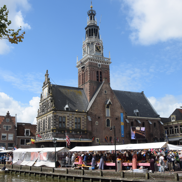 Foto mit Kirche und blauem Himmel, davor der Käsemarkt von Alkmaar